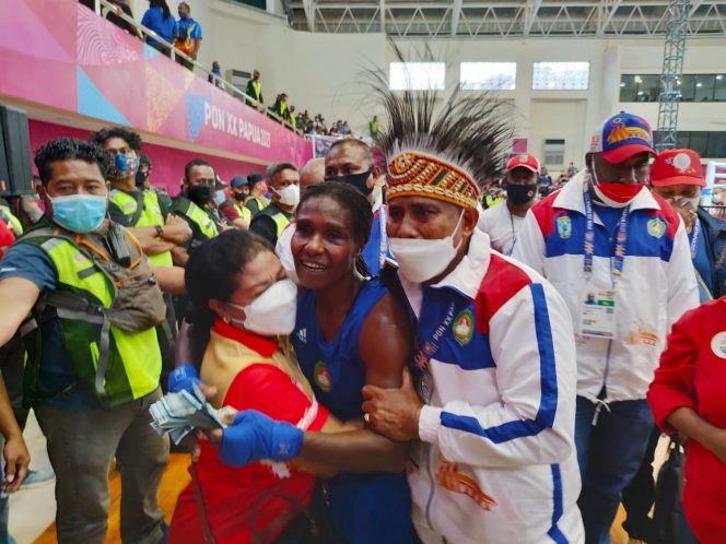 
 Atlet Tinju Papua Barat, Cristina Jembay ketika dipeluk Manager Pertina Papua Barat, usai mengalahkan atlet tinju Kalsel pada partai final tinju PON XX Papua di GOR Cenderawasih, Kota Jayapura, Rabu (13/10/2021)