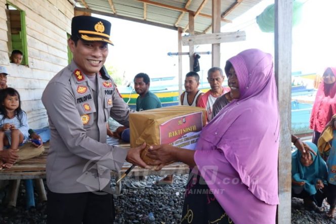 
 Kapolres Manokwari Selatan AKBP Tolopan Simanjuntak saat menyerahkan bantuan kepada perwakilan nelayan di Kampung Abreso, Jumat (9/9/2022)